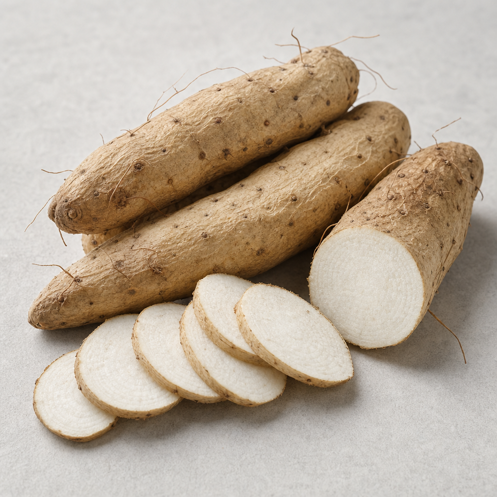 Dried Chinese yam tubers (Dioscorea opposita) with pale tan-brown wrinkled skin beside flat slices showing the dense white starchy interior, arranged on a neutral light-grey surface