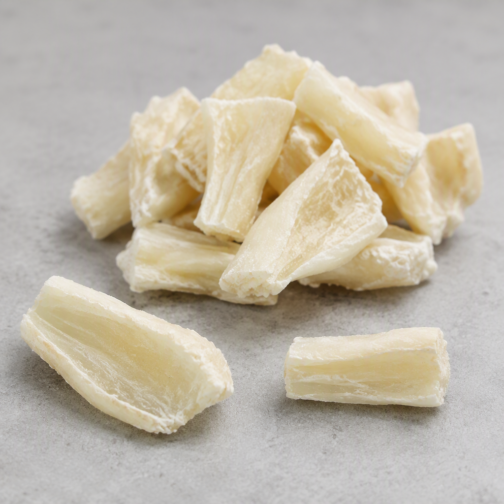 Dried cartilage pieces — small hard off-white to cream chunks with a dense, faintly translucent gristly texture and a matte dry surface, arranged in a pile