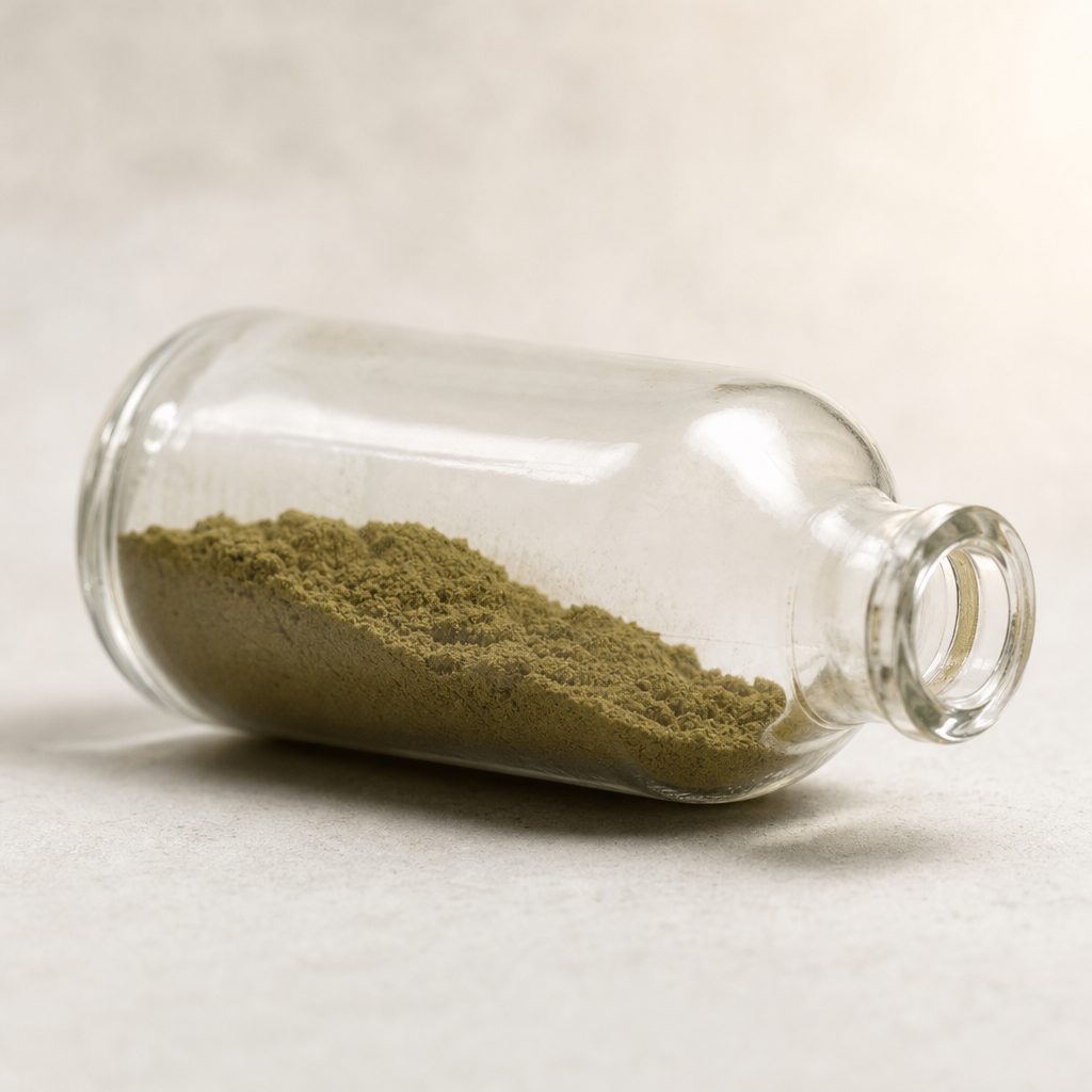 Artemisia extract powder in a glass bottle lying on its side